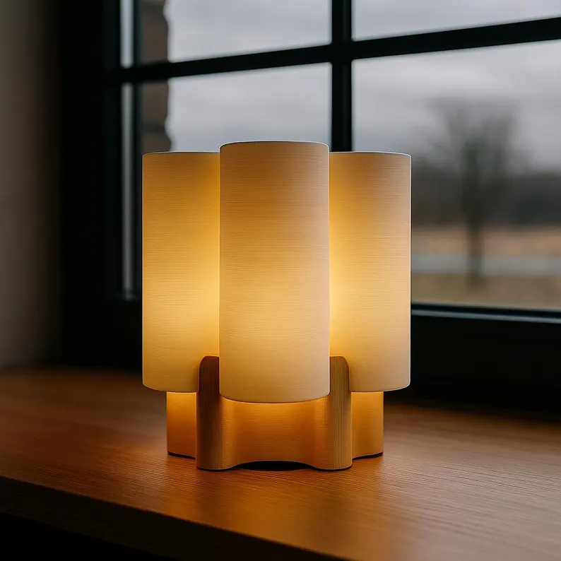 Lámpara EKKO encendida sobre una mesa de madera junto a una ventana