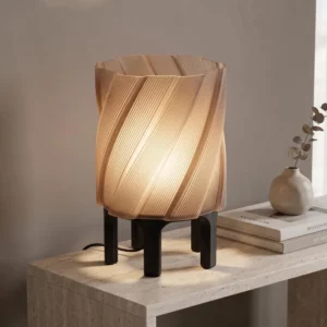 Lámpara Lycora encendida sobre una mesa de travertino