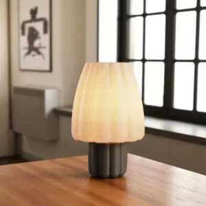 Lámpara Porcini encendida sobre una mesa de madera
